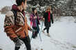© qunica.com - A group of friends hiking through a snowy forest, enjoying outdoor activities and winter exploration while bonding and creating memories with each other in the serene natural surroundings.