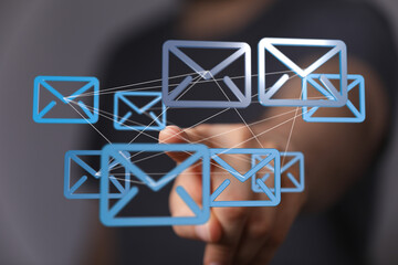 Hand interacting with digital email icons, showcasing global communication and networking.