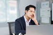 © Crystal - Asian businessman having headache and massaging his head at office desk, tired after long work on laptop computer