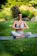 © sepy - Attractive woman wearing sports clothes and doing yoga in the garden at home