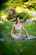 © sepy - Attractive woman wearing sports clothes and doing yoga in the garden at home