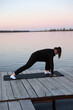 © Anhelina  - Woman practicing yoga on a wooden pier by the water at sunrise. Peaceful atmosphere, healthy lifestyle, balance and harmony with nature. Woman meditating on a yoga mat at wooden pier by the water