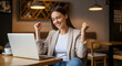 © Passionwith - Euphoric Young Woman Celebrates Success on Laptop in Cafe