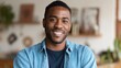 © Johannes - Smiling cheerful young adult african american ethnicity man looking at camera standing at home office background. Happy confident black guy posing for headshot face front close up portrait., no logos