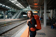 © asier - Young backpacker woman waiting at train station