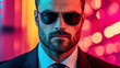 © tashechka - Stylish man in sunglasses poses confidently in vibrant lights at night