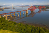 Aerial image featuring the Forth bridge with the Forth Road Bridge and Queensferry crossing Bridge on the background. Edinburgh - Scotland. 