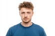 © Popelniushka - Expressionless Youth: Close-Up Portrait of a Young European Man in a Blue T-Shirt Against a White Background
