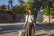 © Miljan Živković - happy adult woman explore and walk through cit with suitcase