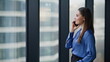 © stockbusters - Employee enjoy phone communication standing by office window smiling closeup.