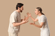 © Pixel-Shot - Angry young couple quarreling on beige background. Dialogue concept