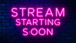 © Zeeshan - A neon sign on a brick wall that says stream starting soon in bright pink glowing letters on a dark background