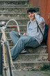 © carballo - student sitting on the street with mobile phone and bicycle