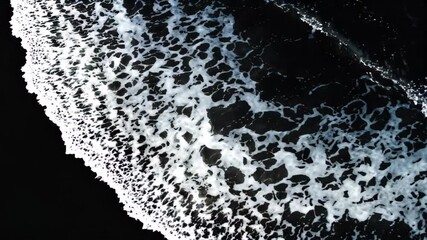 Wall Mural - surfers are riding the waves on the black sand of the beach