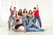 © New Africa - Group of happy teenagers waving on sofa indoors