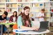 © New Africa - Student with laptop studying at table in library