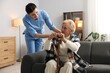 © New Africa - Nurse assisting senior woman with walking cane indoors. Home health care service