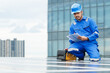 © DG PhotoStock - Electrical engineer inspecting and installing a solar panels on the building rooftop.