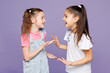 © ViDi Studio - Little smiling cheerful cool two friends kids children girls 9-10 years old wear casual clothes together talking with each other laugh have fun isolated on plain purple background. Lifestyle concept.