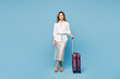 © ViDi Studio - Traveler happy employee business woman wear formal clothes hold suitcase bag isolated on plain blue background. Tourist travel abroad in free spare time rest getaway. Air flight trip journey concept.