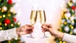 © TheShotSpot - Two people toasting with champagne glasses in front of a decorated Christmas tree.