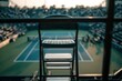 © Bagas - Empty umpire chair on tennis court, blurred spectators