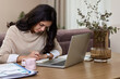 © Rychko Yevhen - Beautiful woman in shirt using laptop while working at home