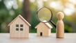 © N7 - Wooden figure holding magnifying glass in front of tiny homes — searching smart real estate deals