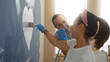 © Krakenimages.com - Hispanic couple decorating new home together painting wall indoors man and woman smiling creating heart shape in cozy living room reflecting love and teamwork