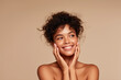 © Impressionstock - Radiant Beauty: A young woman with radiant skin and a warm smile touches her face gently, showcasing natural beauty and confidence.