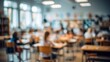 © Harry - Soft focus classroom scene showing desks and students studying under bright lights in warm tones with muted colors.