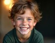 © Maryna - Young boy smiles directly at camera outdoors near trees with soft golden light. Wears green shirt, messy brown hair, blue eyes, joyful expression. Portrait captures childhood innocence, happiness,