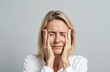 © Viktor - Mature blonde woman suffers from headache rubbing temples. European adult model shows displeasure with closed eyes. Portrait shows cephalalgia symptom with facial expression of pain, discomfort in
