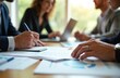 © Maryna - Diverse team collaborates in office, focusing on laptops, documents. Professionals discuss business, finance, strategy, showing teamwork, productivity. Natural light enhances modern, efficient