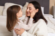 © Pixel-Shot - Daughter touching her mother's face with tenderness in bedroom