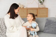 © Pixel-Shot - Mother and her little daughter with teddy bear in living room