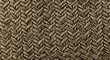 © Maharadis_Artwork - Close-up of a woven natural fiber material, creating a textured herringbone pattern with a warm, earthy tone.
