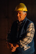 © Ljustina - Senior construction worker wearing yellow hard hat posing in building under construction