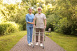 © New Africa - Smiling nurse supporting elderly man who using walking frame outdoors