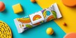 © Inkwell Imagery - Colorful snack bar packaging with modern abstract design on vibrant yellow and blue background for branding.