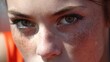 © Anastasia - Close-up of a young woman's face. she has fair skin and freckles on her face. her eyes are looking directly at the camera with a serious expression.