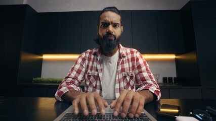 POV of focused Indian IT developer typing code on laptop, remote freelance work
