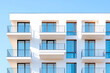 © A2Z AI  - Modern architecture showcased through a building facade featuring sleek balconies and windows against a serene blue sky, highlighting contemporary design.