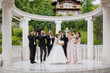 © Vasil - Wedding celebration with joyful couple and party in elegant outdoor venue