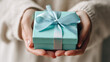 © HotmaHimmawan - Elegant Hands Holding Gift Box with Blue Ribbon - Perfect Gift Photography