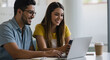 © Anisgott - Smiling Young Couple Using Laptop and Smartphone Together at Desk