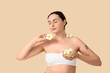 © Pixel-Shot - Young woman with bath bombs and plumeria flowers on beige background