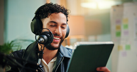 Live streaming, influencer and man with mic, tablet and read script for episode or content creation. Happy, podcaster and person with tech for entertainment, online and headphones for audio in studio
