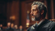 © Milon - Profile shot of a judge with gray hair and beard in a courtroom setting looking right