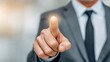 © Prapan - Digital touch concept: A close-up shot captures a sharply dressed figure in a gray suit, his finger extended to interact with an unseen digital interface.